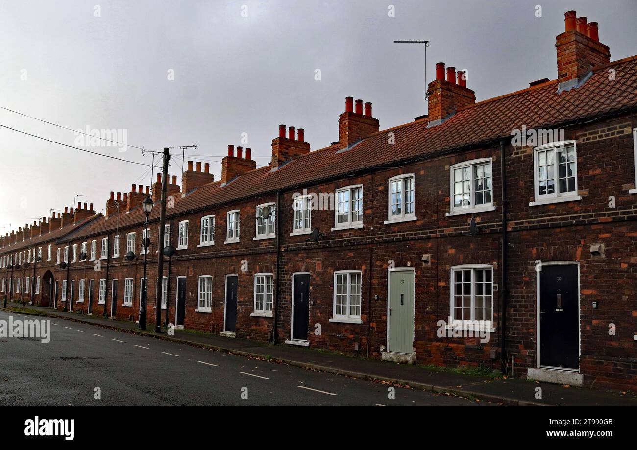 Windows, doors and chimneys of terraced houses on a wide Cliff Street which is part of the New Frodingham village in Scunthorpe in Lincolnshire. Stock Photo