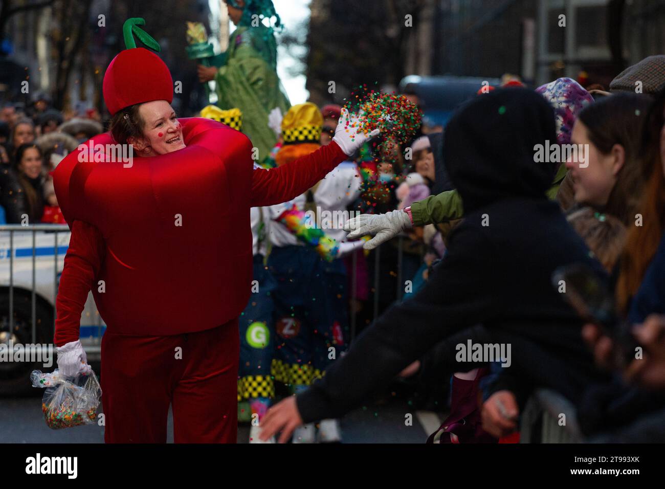 New York, United States. 23rd Nov, 2023. A parade performer is throwing confetti to the crowd at