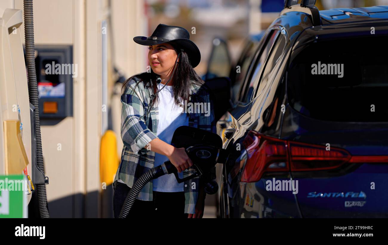 Young woman filling up her SUV car at a gas station Stock Photo - Alamy