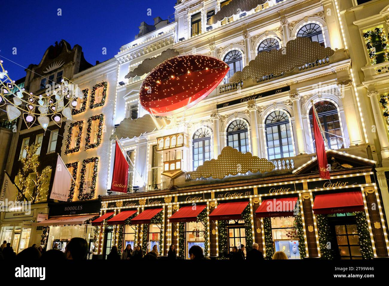 London, UK. 23rd November, 2023. The Cartier store front during dusk. Visitors and shoppers admire the Christmas shop displays in New Bond Street and Old Bond Street, which also feature festive lights inspired by the Crown Jewels. Credit: Eleventh Hour Photography/Alamy Live News Stock Photo
