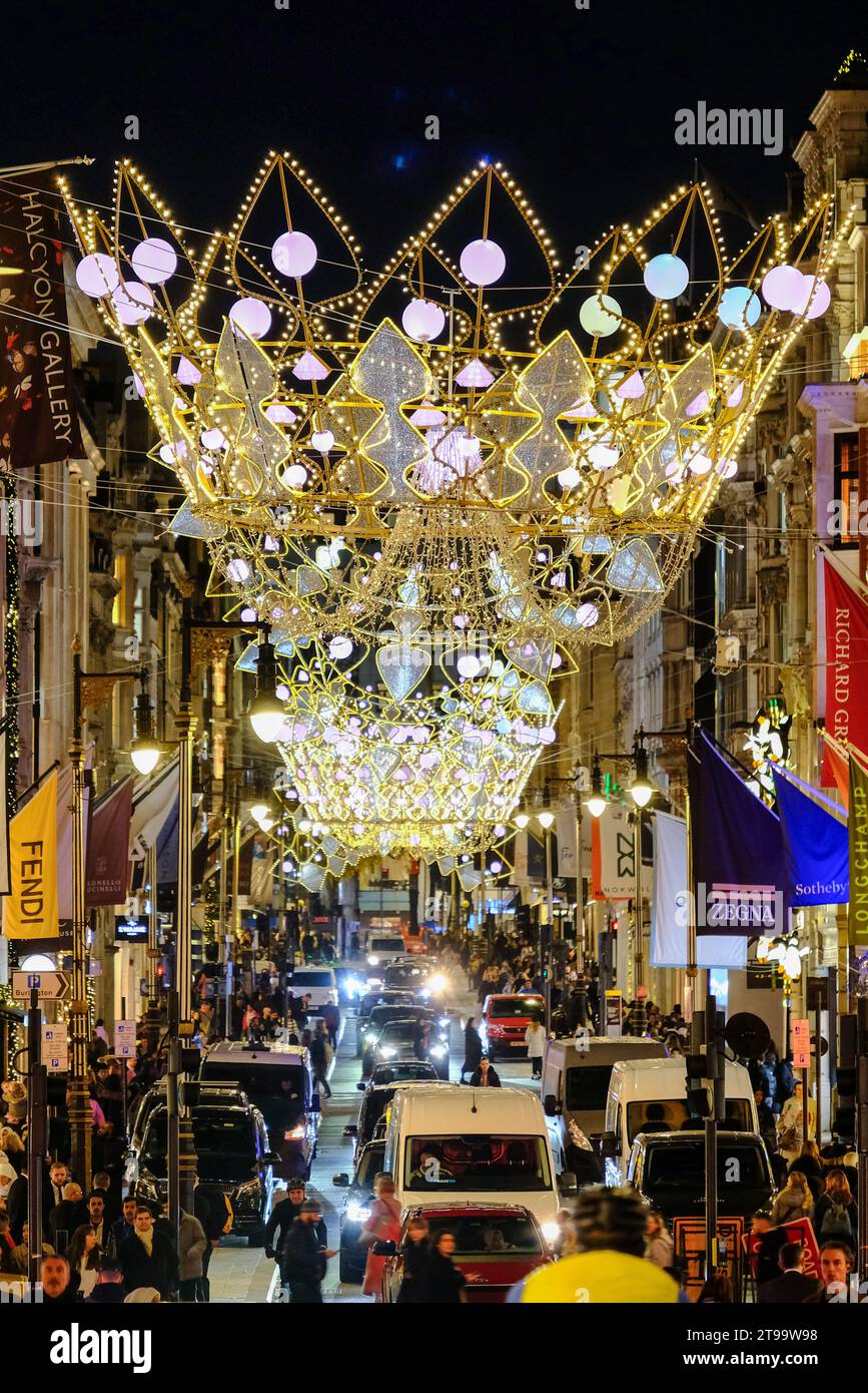 London, UK. 23rd November, 2023. Visitors and shoppers admire the Christmas shop displays in New Bond Street and Old Bond Street, which also features festive lights inspired by the Crown Jewels. Credit: Eleventh Hour Photography/Alamy Live News Stock Photo