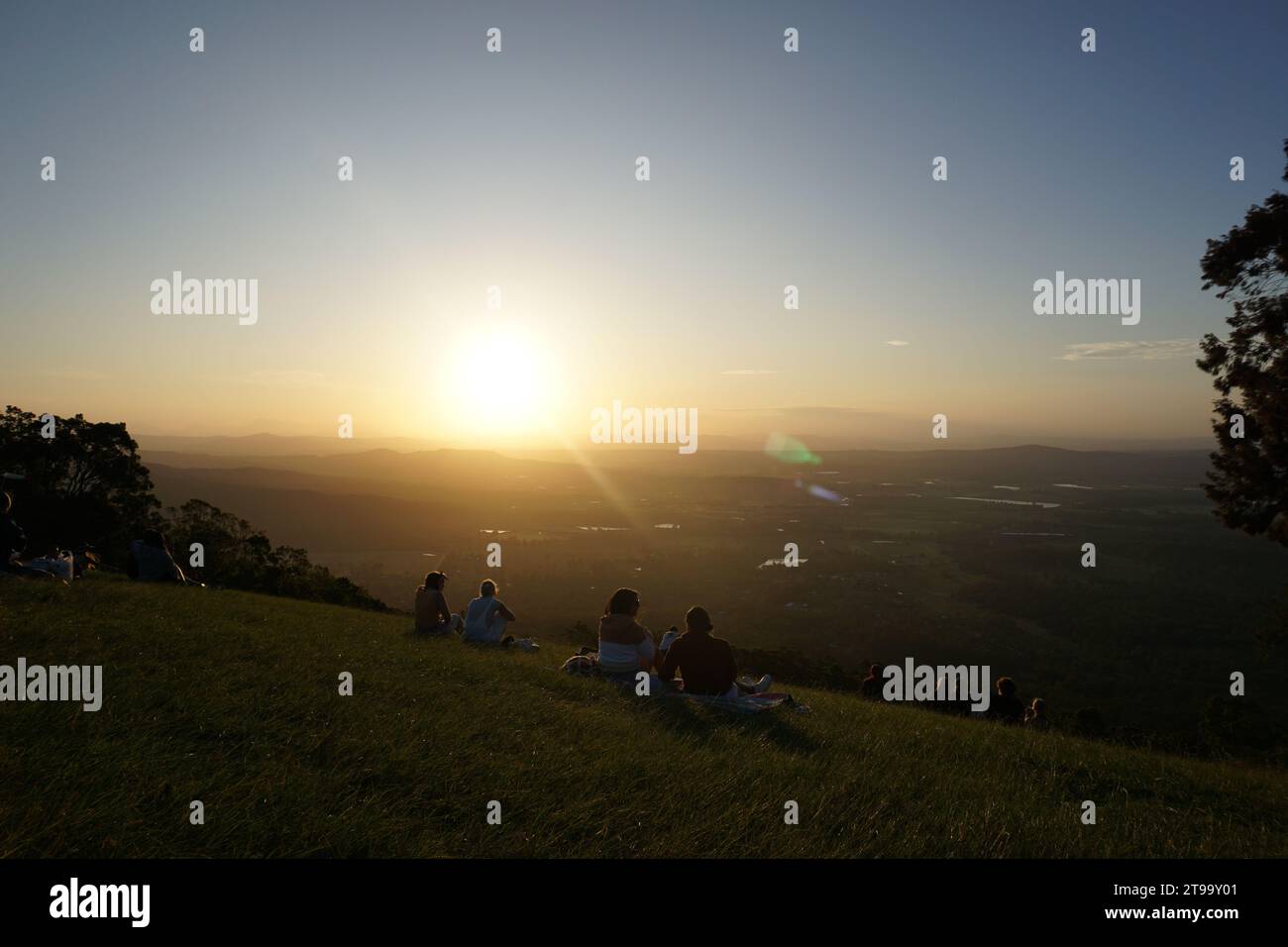 People watchin dramatic colourful orange sunset with lens flare. Rotary