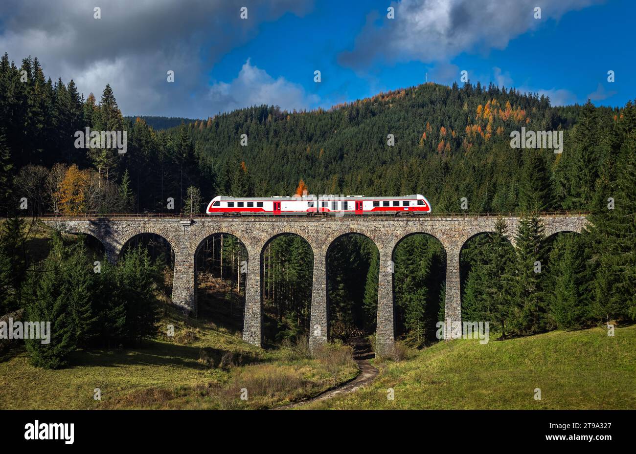 Telgart, Slovakia - The famous Chmarossky Viaduct in the low Tatras on a sunny autumn day with blue sky and clouds. Regular train is going through the Stock Photo