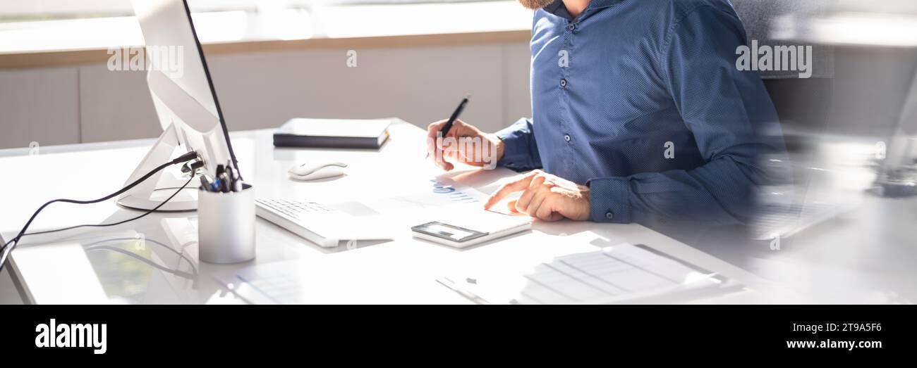 Accountant Man Using Computer Software to Calculate Invoices Stock Photo