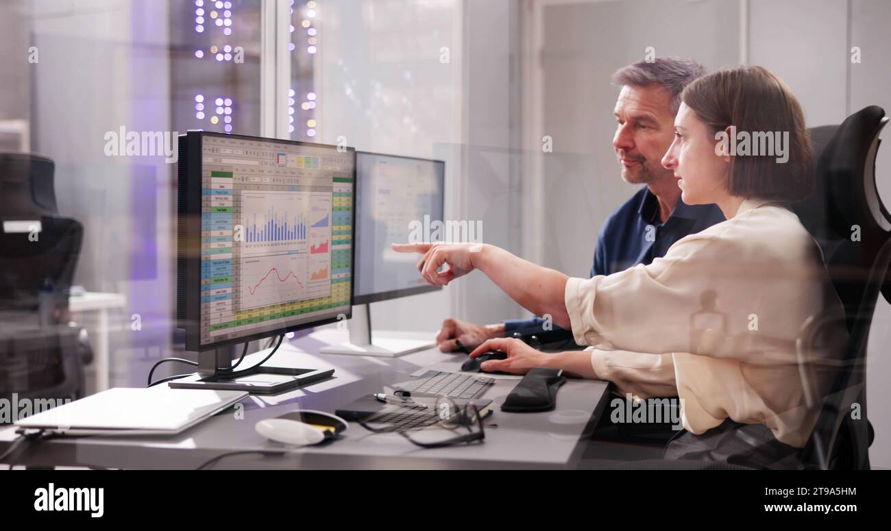 Working Analyst on Desktop Computer with Spreadsheets Stock Photo