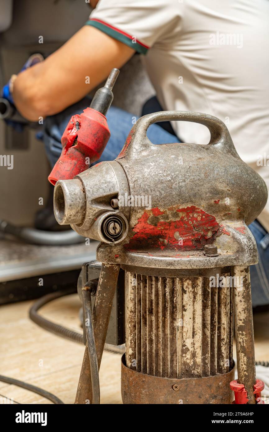 https://c8.alamy.com/comp/2T9A6HP/plumber-using-equipment-to-remove-grease-from-the-drain-pipe-at-vertical-composition-2T9A6HP.jpg