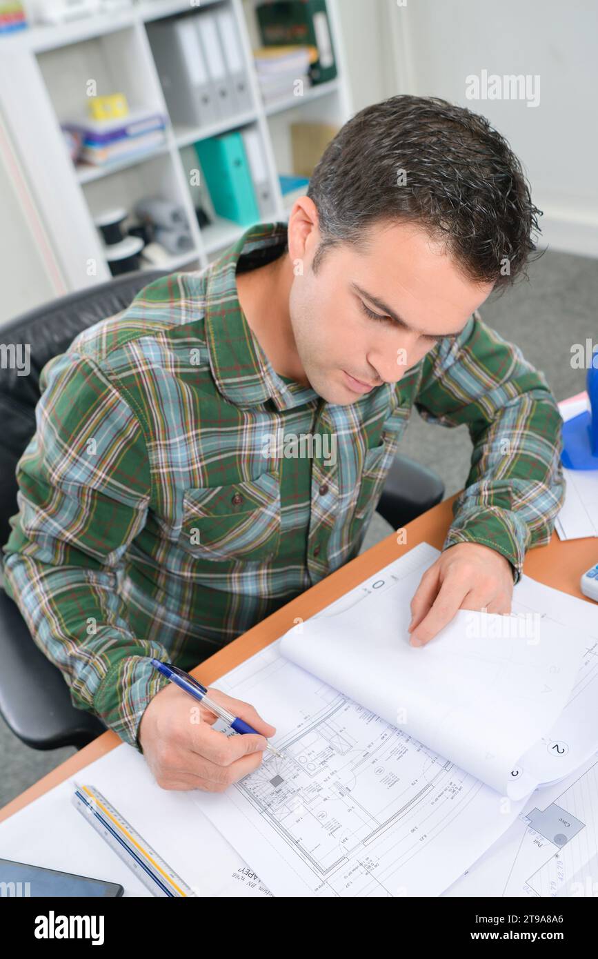 Man at desk working on plans in file Stock Photo