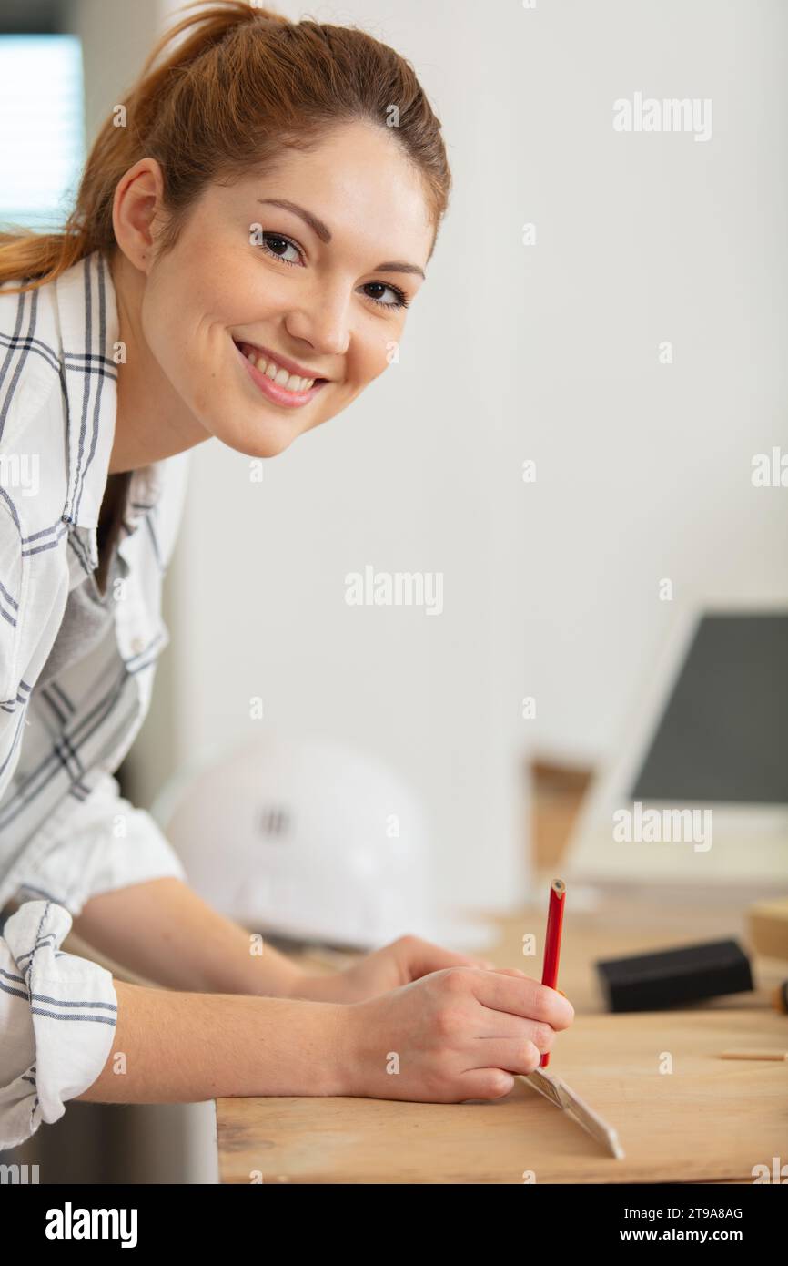 female repairman carpenter cutting joining wooden planks doing r Stock Photo