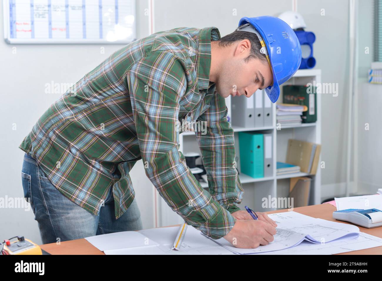 Builder making notes on paperwork Stock Photo