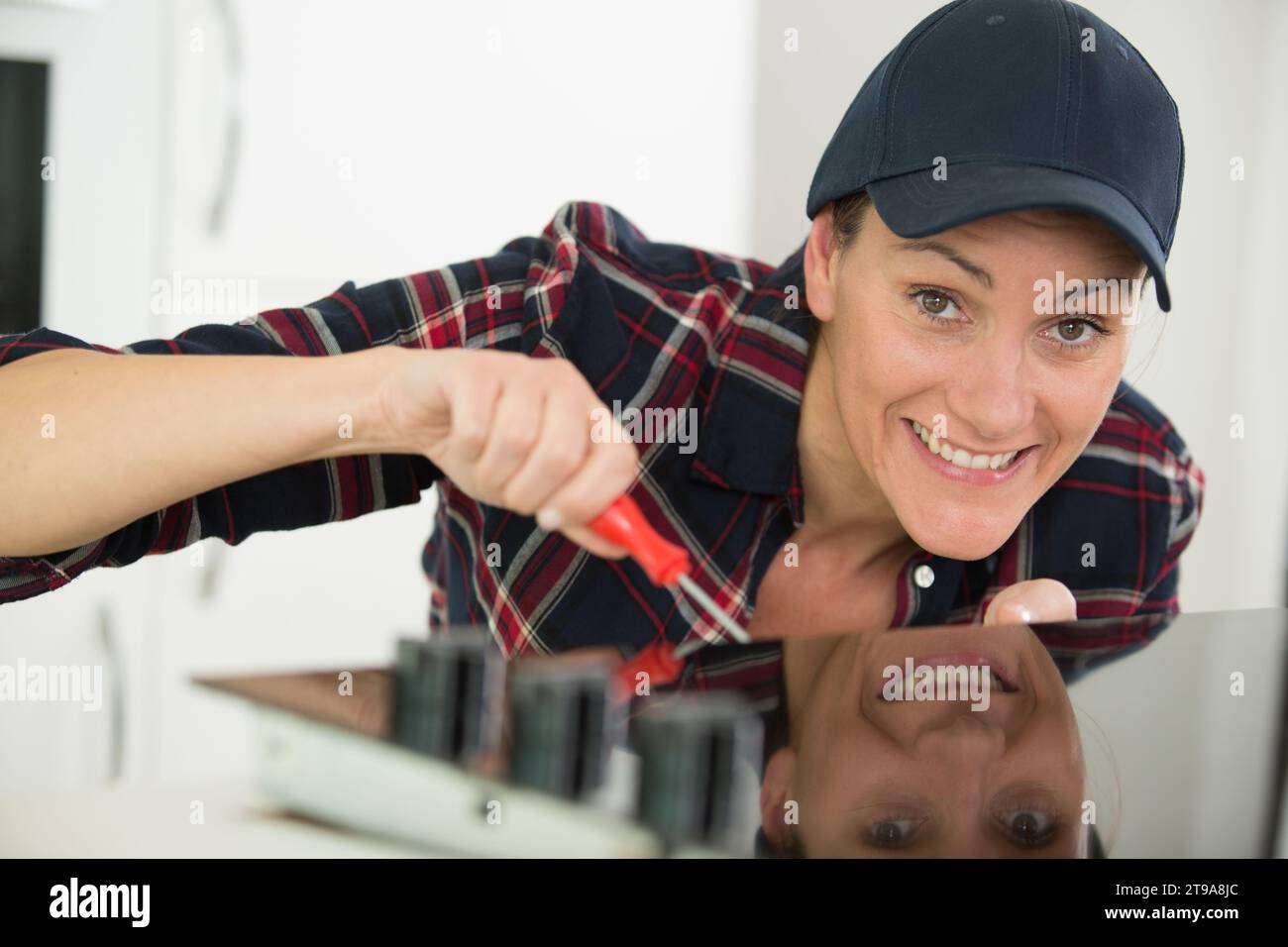 woman installing induction hobs in a kitchen Stock Photo