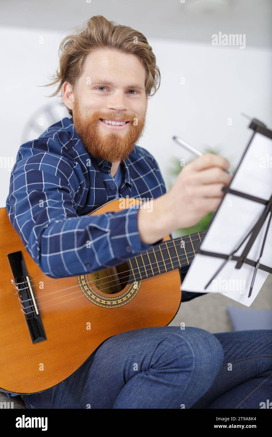 attractive bearded man learning a song Stock Photo