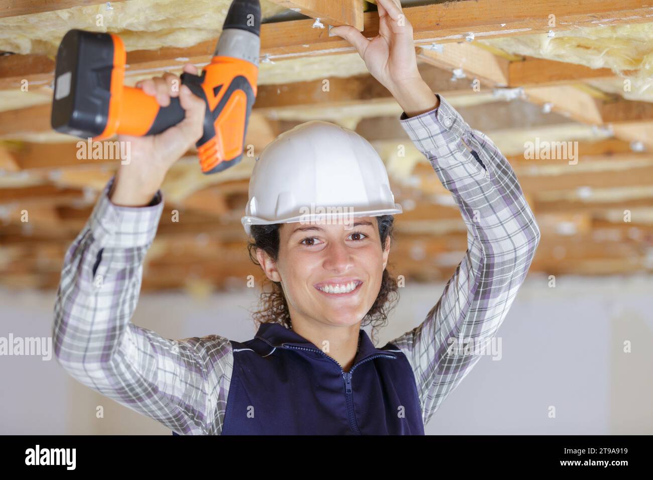 happy female worker drilling ceiling Stock Photo - Alamy