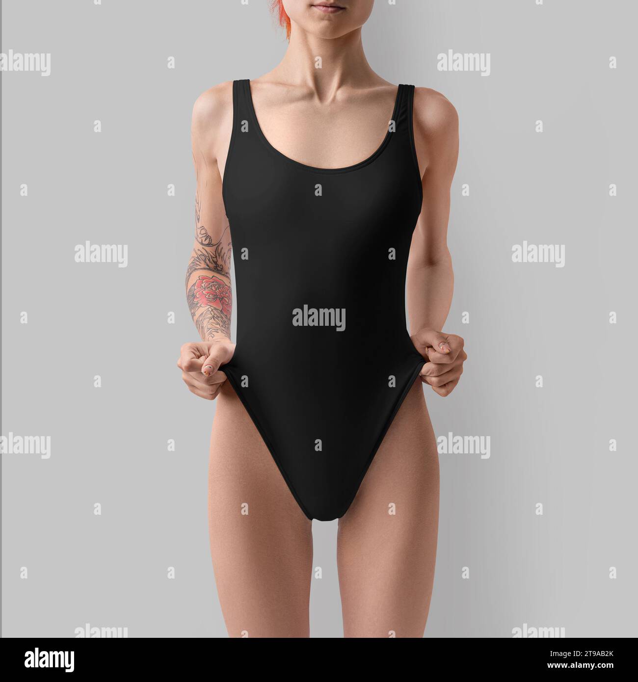 Template of a black sports swimsuit on a girl with a tattoo on her arm, fashionable swimwear for design, branding. Mockup of bodysuits, swimming cloth Stock Photo