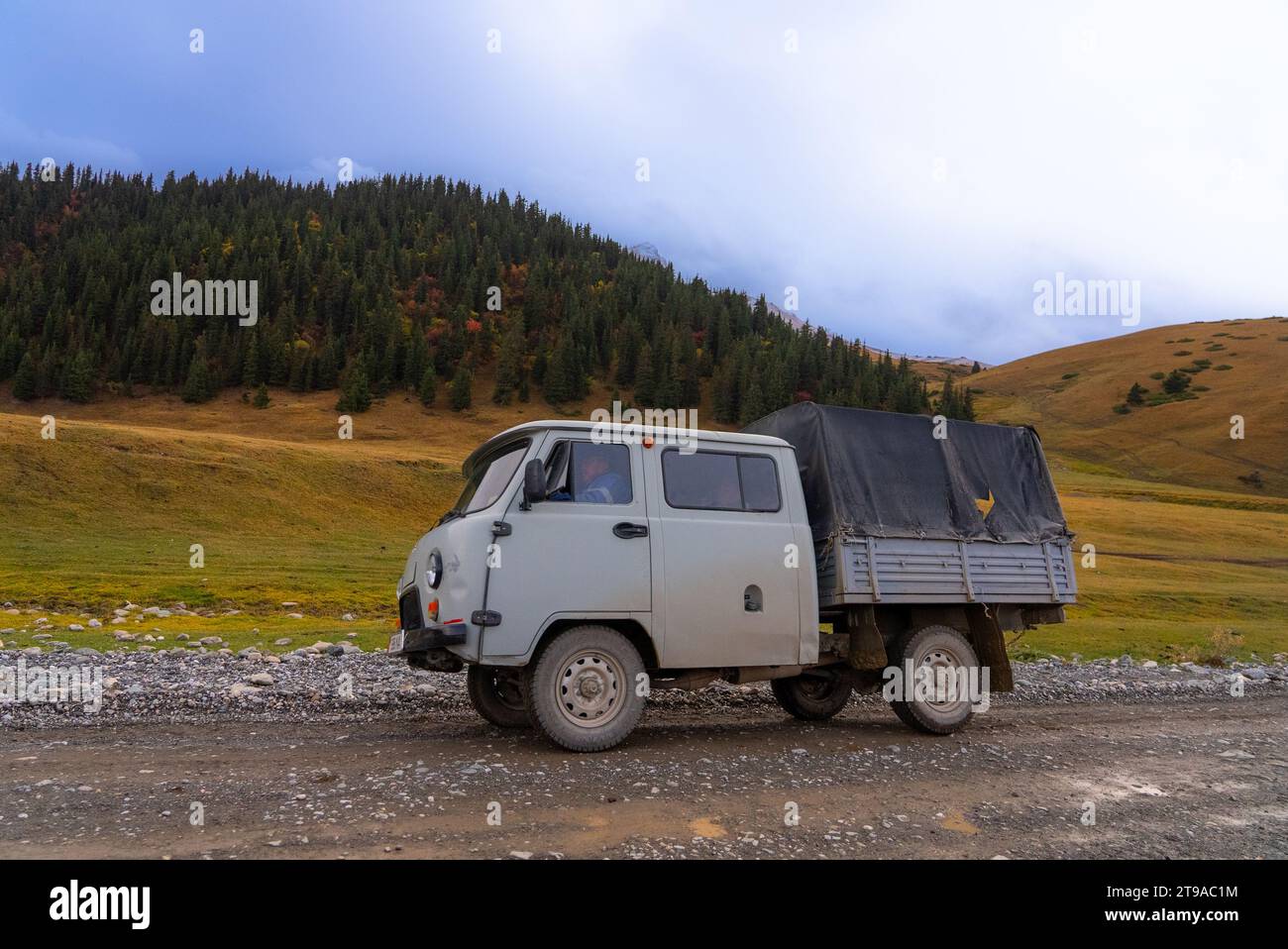 Old Russian truck in use on a rural dirt road in Kyrgyzstan Stock Photo