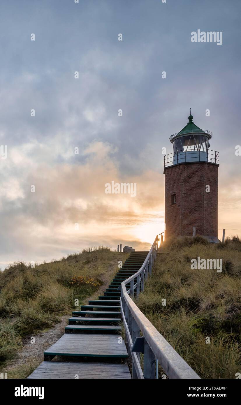 Wooden footbridge and stairs through the dunes to the lighthouse, lighthouse Quermarkenfeuer Rotes Kliff, dunes, Kampen, evening mood, North Sea Stock Photo