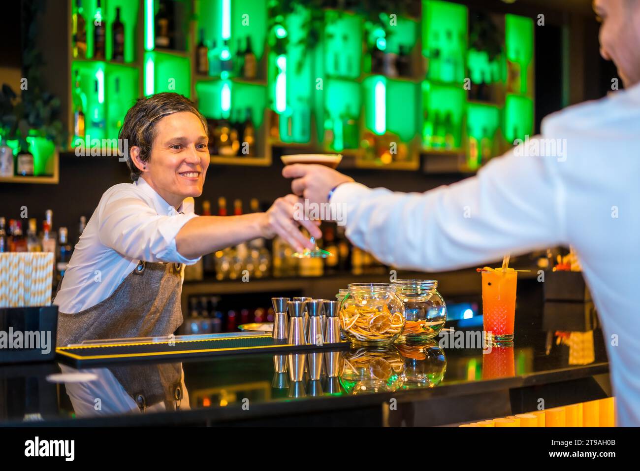 Bartender serving a martini cocktail in a luxury bar to a man Stock ...
