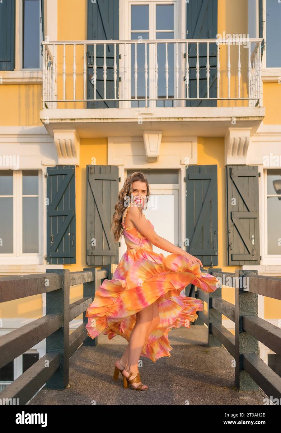 Vertical photo with copy space of a beauty woman dancing while walking along a coastal bridge Stock Photo