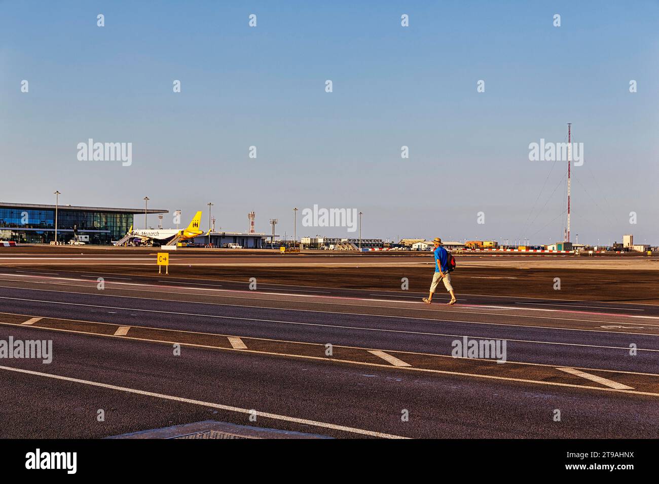 Tourist walking on Winston Churchill Avenue, crossing airport runway, Royal Air Force Station