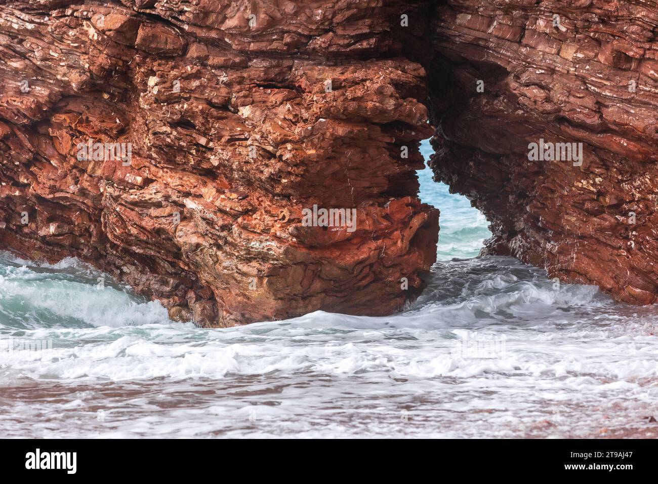 Wild beach Crvena Glavica in Montenegro. Red rocks coast arch and water ...