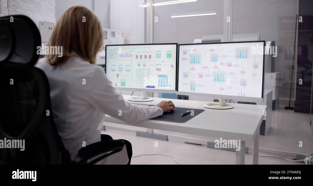 High-Tech Office: Engineer Analyzing Software Data on Computer Monitor Stock Photo