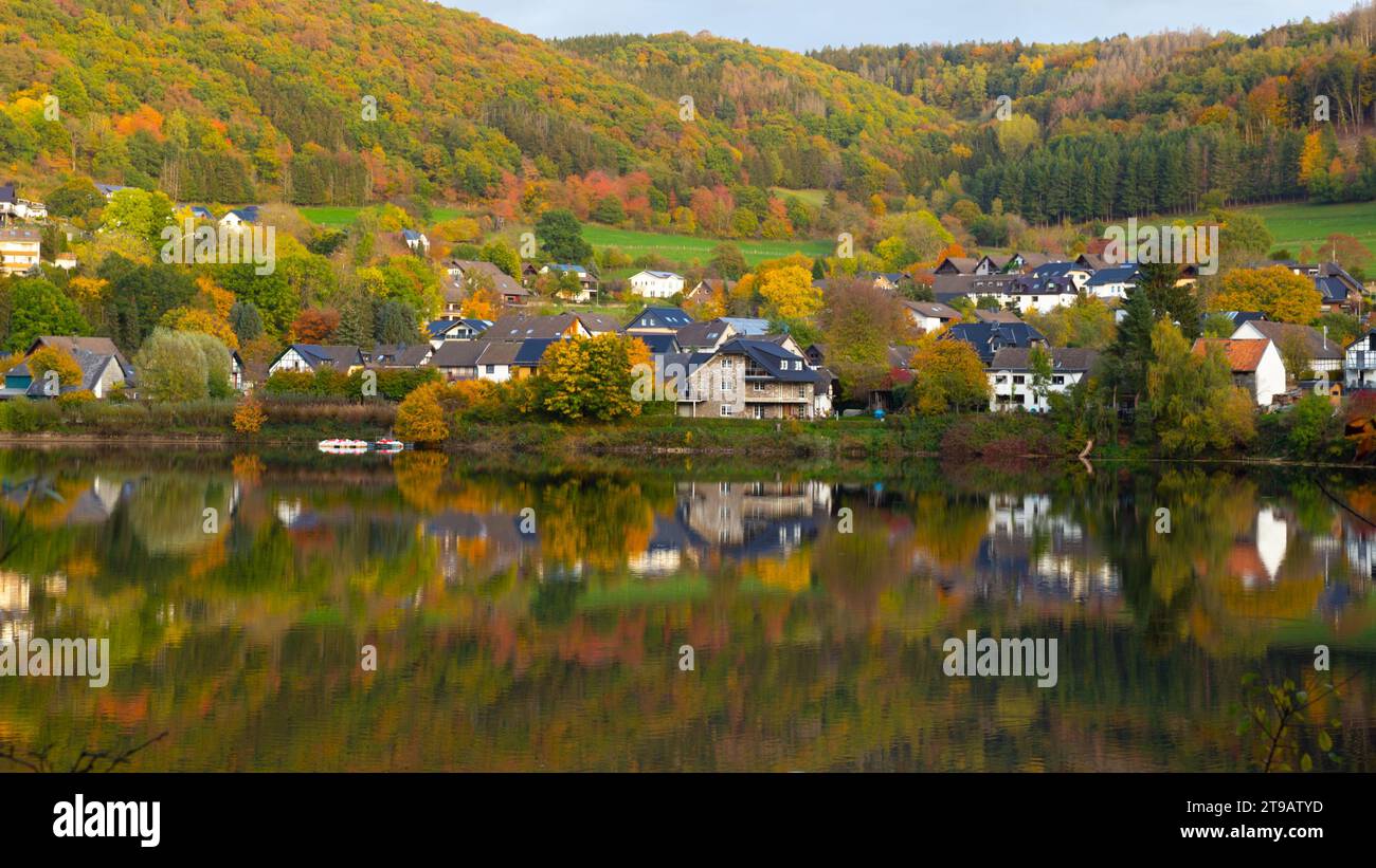 Beautiful german village with colorful foliage forest in the background