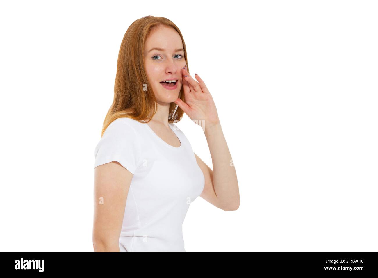 Young woman telling something, red head girl telling a secret. Portrait young happy woman who is calling to someone. Funny girl model whispering about Stock Photo