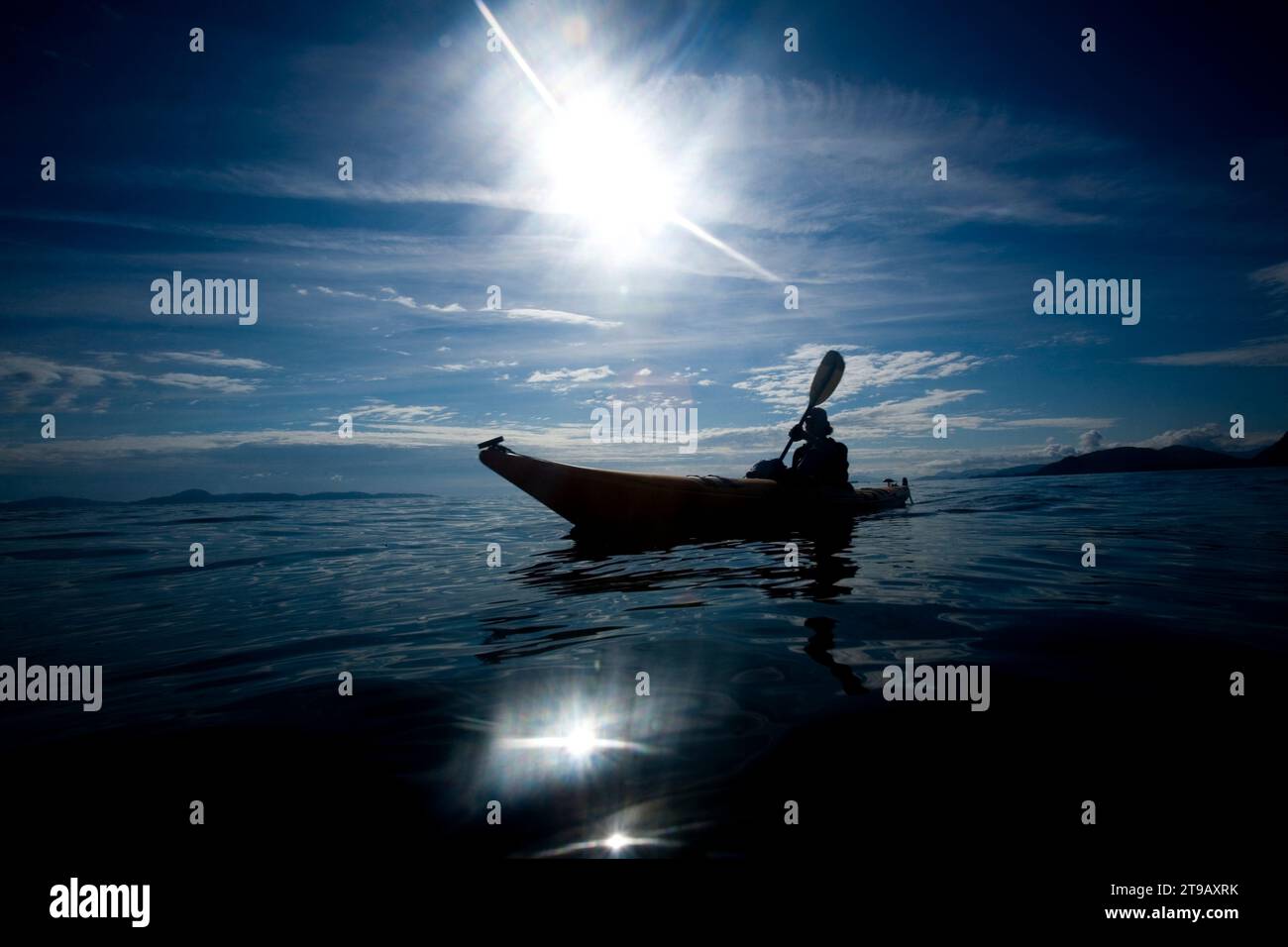 Silhouette of a person sea kayaking Stock Photo - Alamy