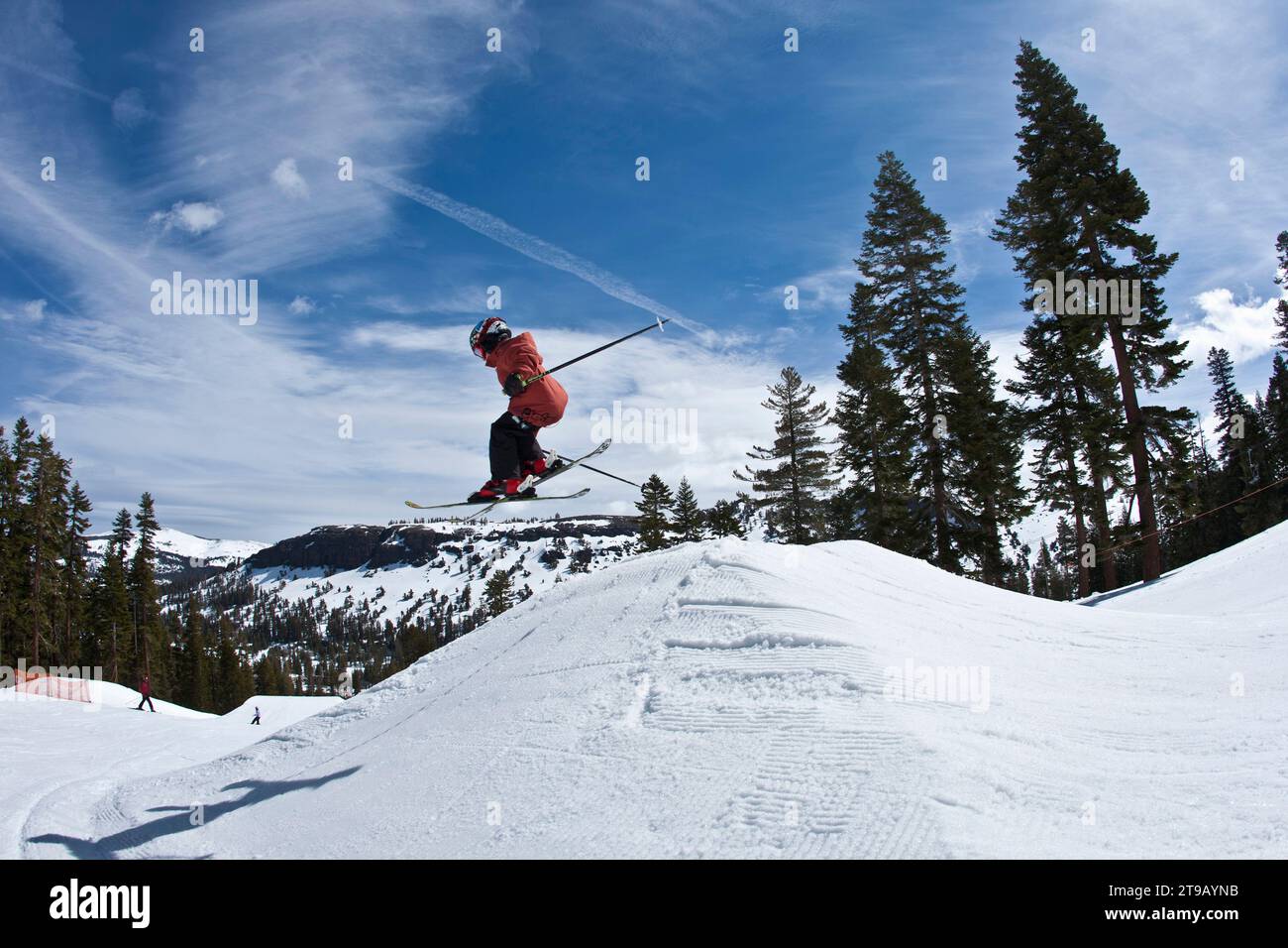 Young skier hitting a jump. Stock Photo