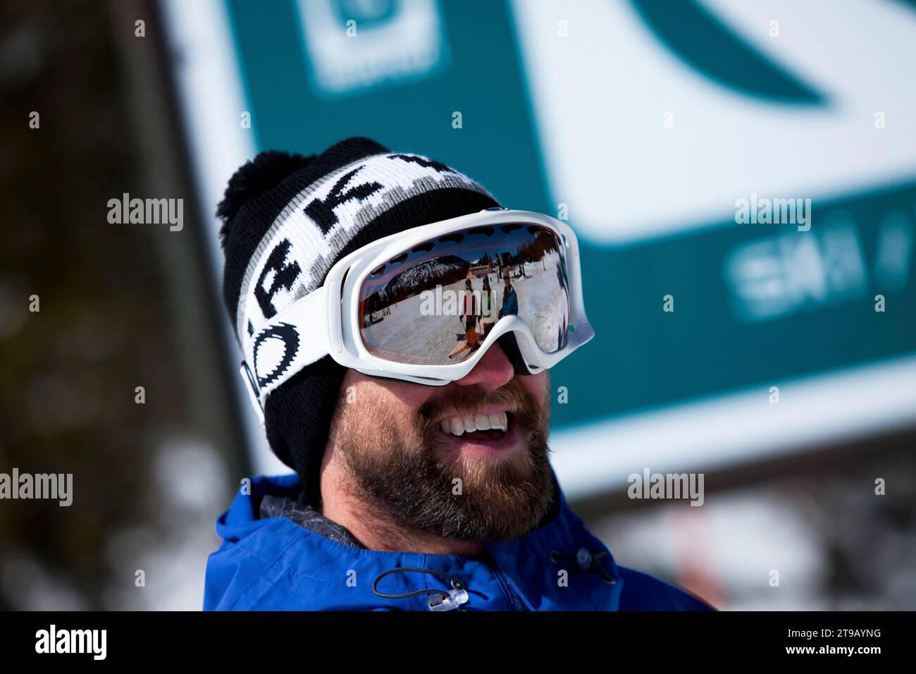 Skiers reflected in a male skier's goggles. Stock Photo