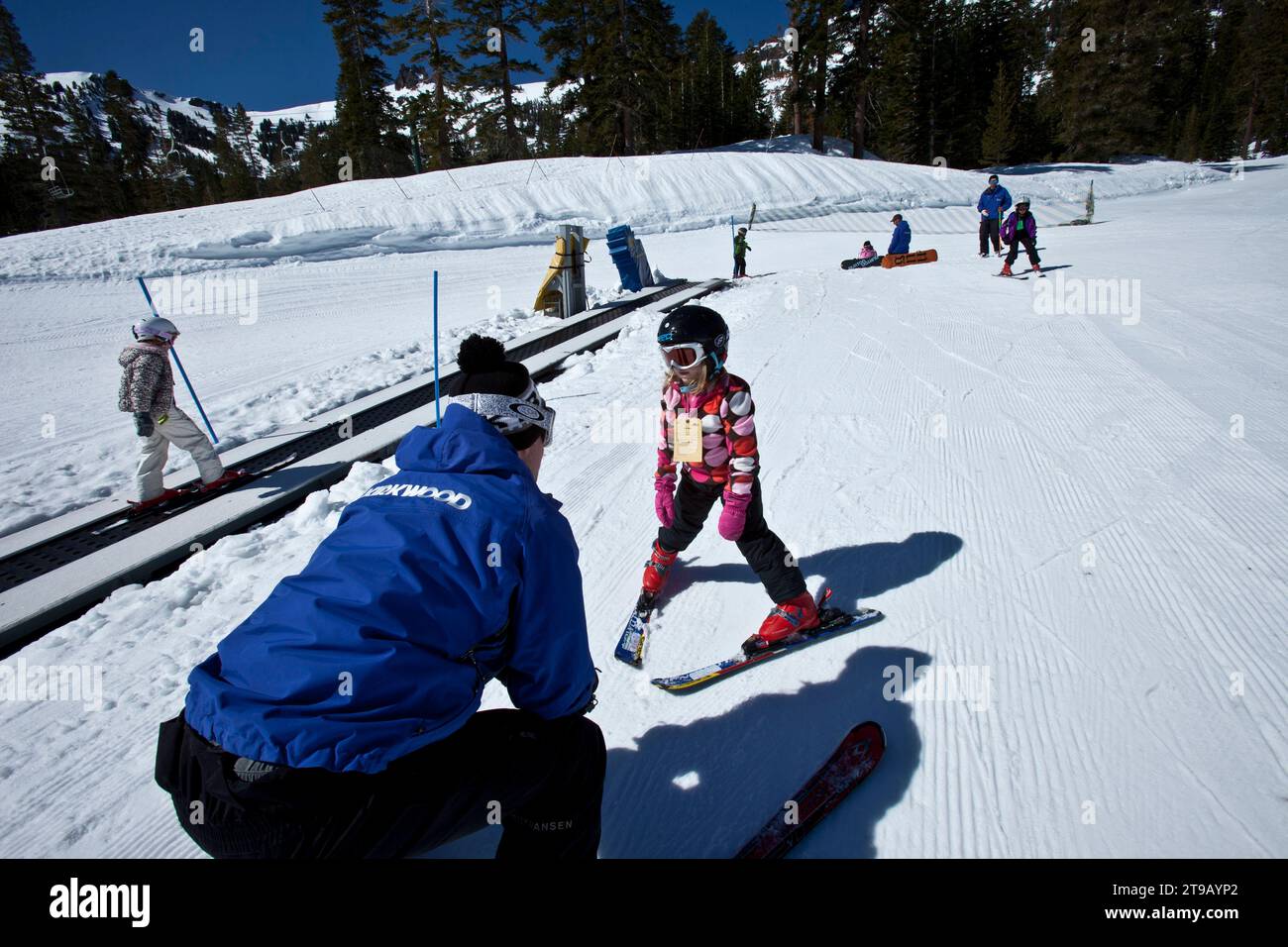 Ski Instructor helping a young skier on a bunny slope. Stock Photo