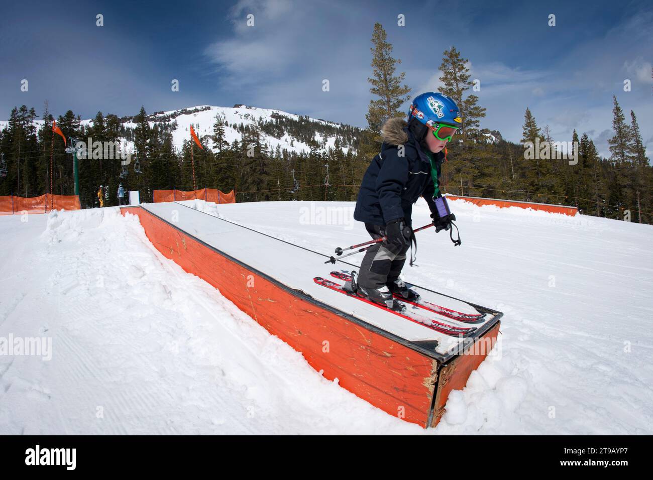 Young skier on a box in a terrain park. Stock Photo