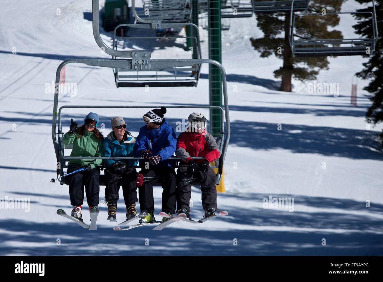 Ski instructor with his class having fun on a chairlift. Stock Photo