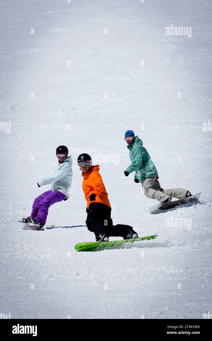 Snowboard instructor riding and giving a snowboard lesson at a ski resort. Stock Photo