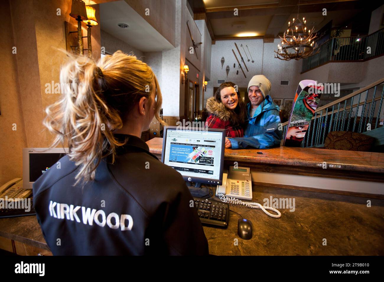 Young couple checking in to a ski lodge / hotel. Stock Photo