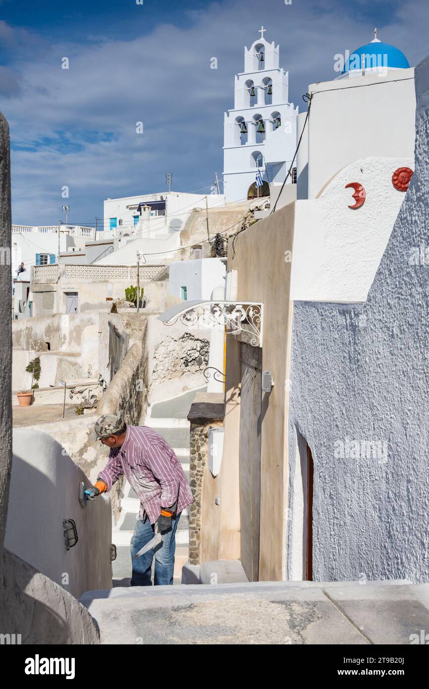 Bricklayer smoothing a wall in Pyrgos Kallistis village, Santorini Stock Photo