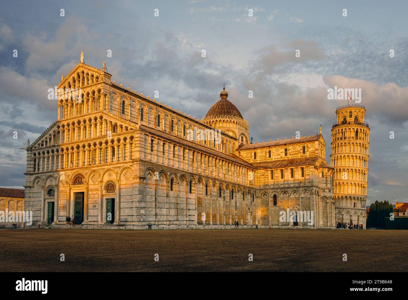 The city of Pisa historic plaza with the Pisa cathedral and the leaning tower illuminated by the golden hour light. Photo taken on 22nd of October 202 Stock Photo