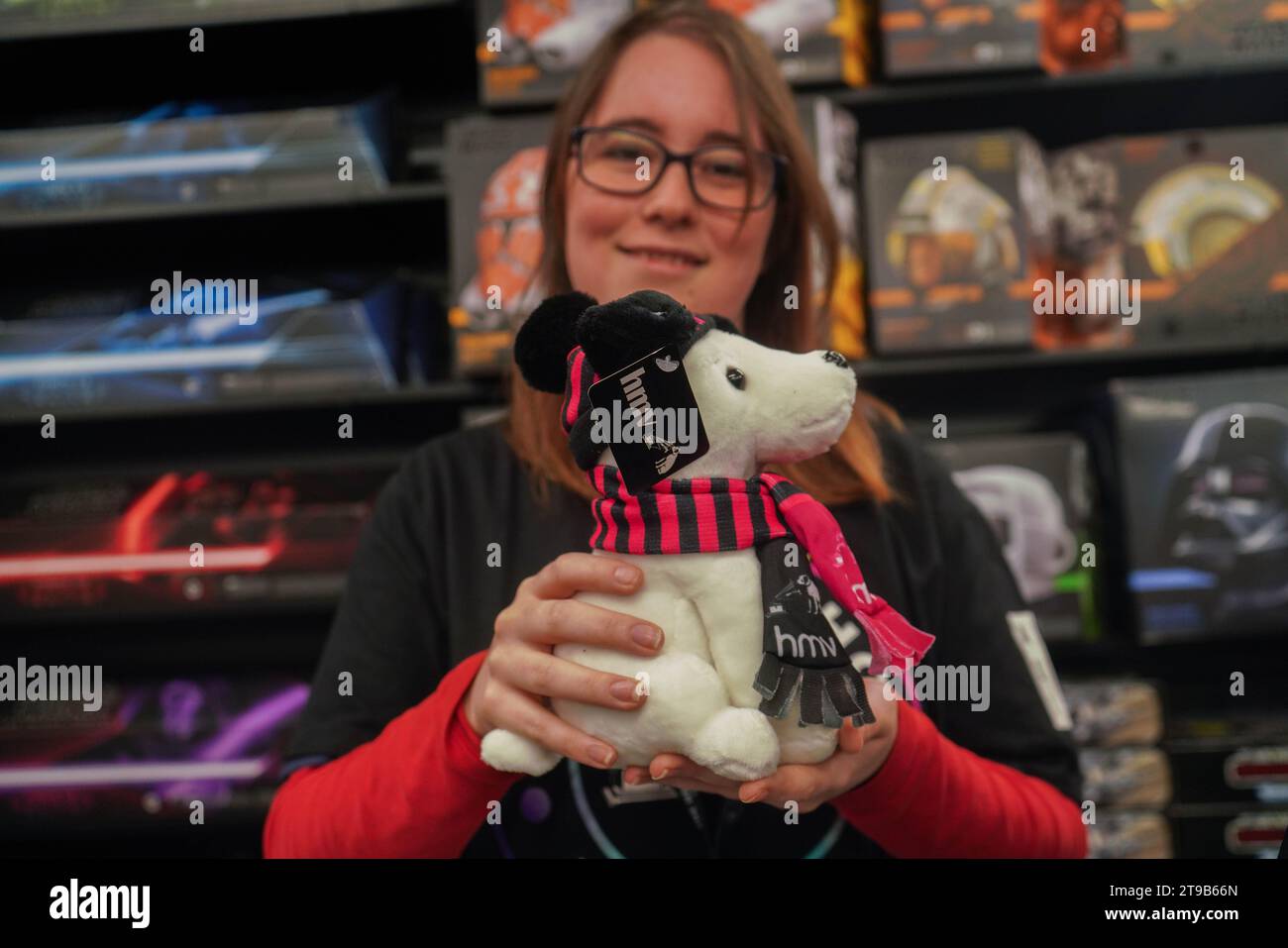 London, UK. 24 November 2023. An HMV staff holds a merchandise doll of