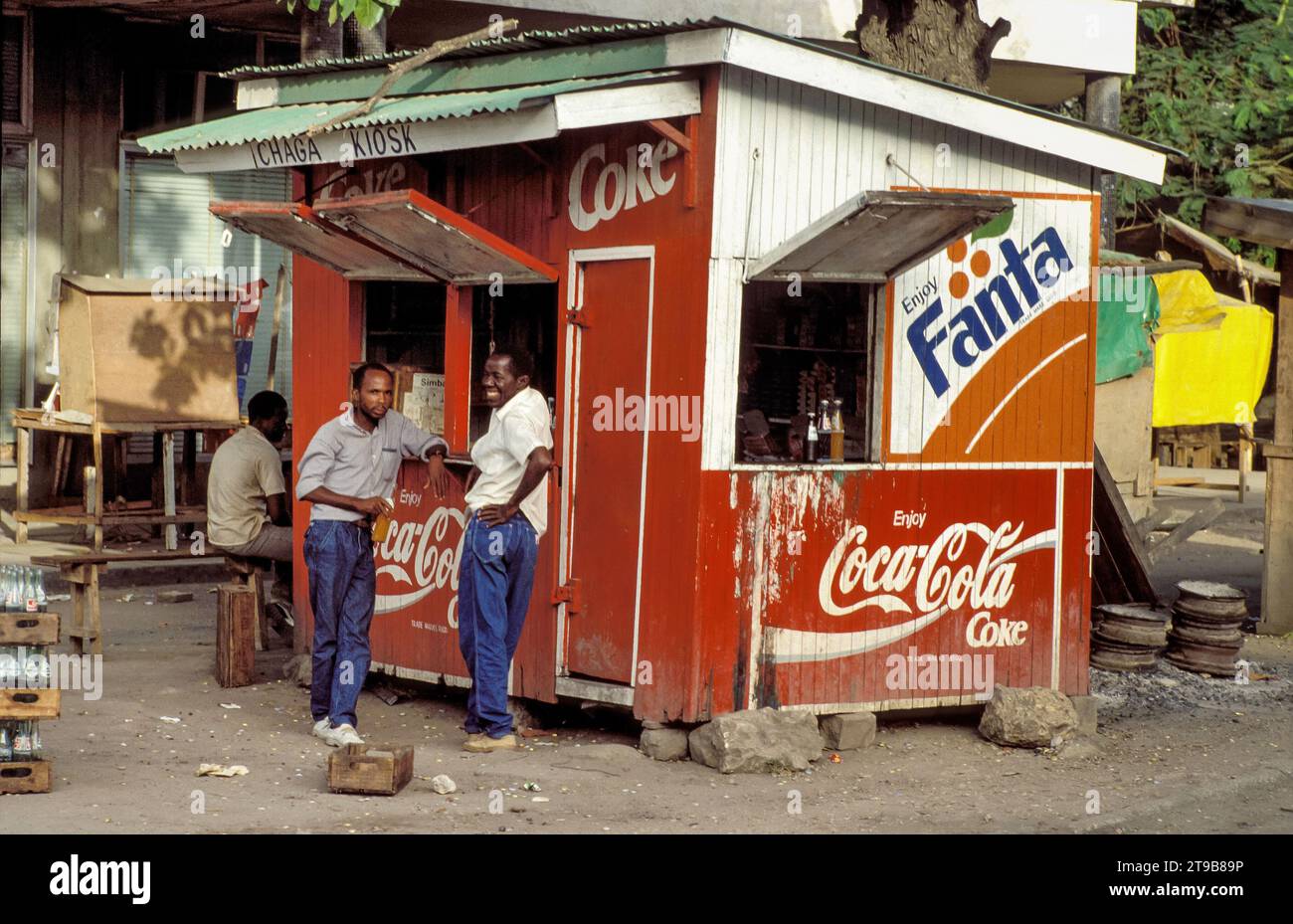 Tanzania, DaresSalaam Men drink a soft drink at a kiosk in the