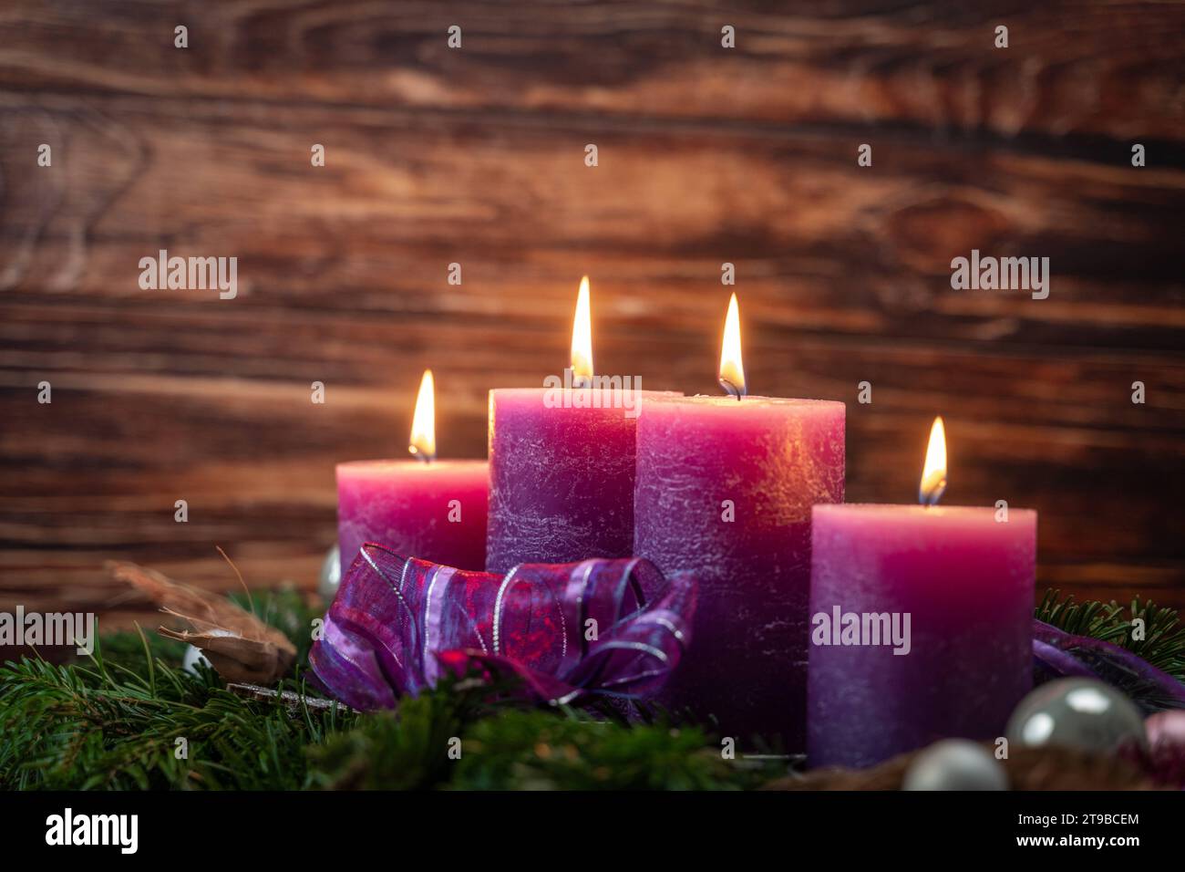 Augsburg, Bavaria, Germany - November 24, 2023: Christmas wreath with four burning purple candles for Advent *** Weihnachtskranz mit vier brennenden lila Kerzen zur Adventszeit Credit: Imago/Alamy Live News Stock Photo