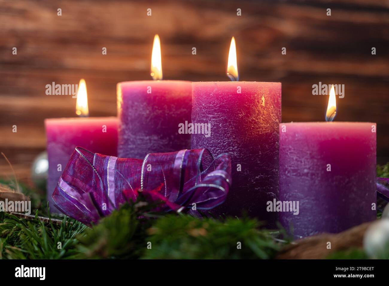 Augsburg, Bavaria, Germany - November 24, 2023: Christmas wreath with four burning purple candles for Advent *** Weihnachtskranz mit vier brennenden lila Kerzen zur Adventszeit Credit: Imago/Alamy Live News Stock Photo