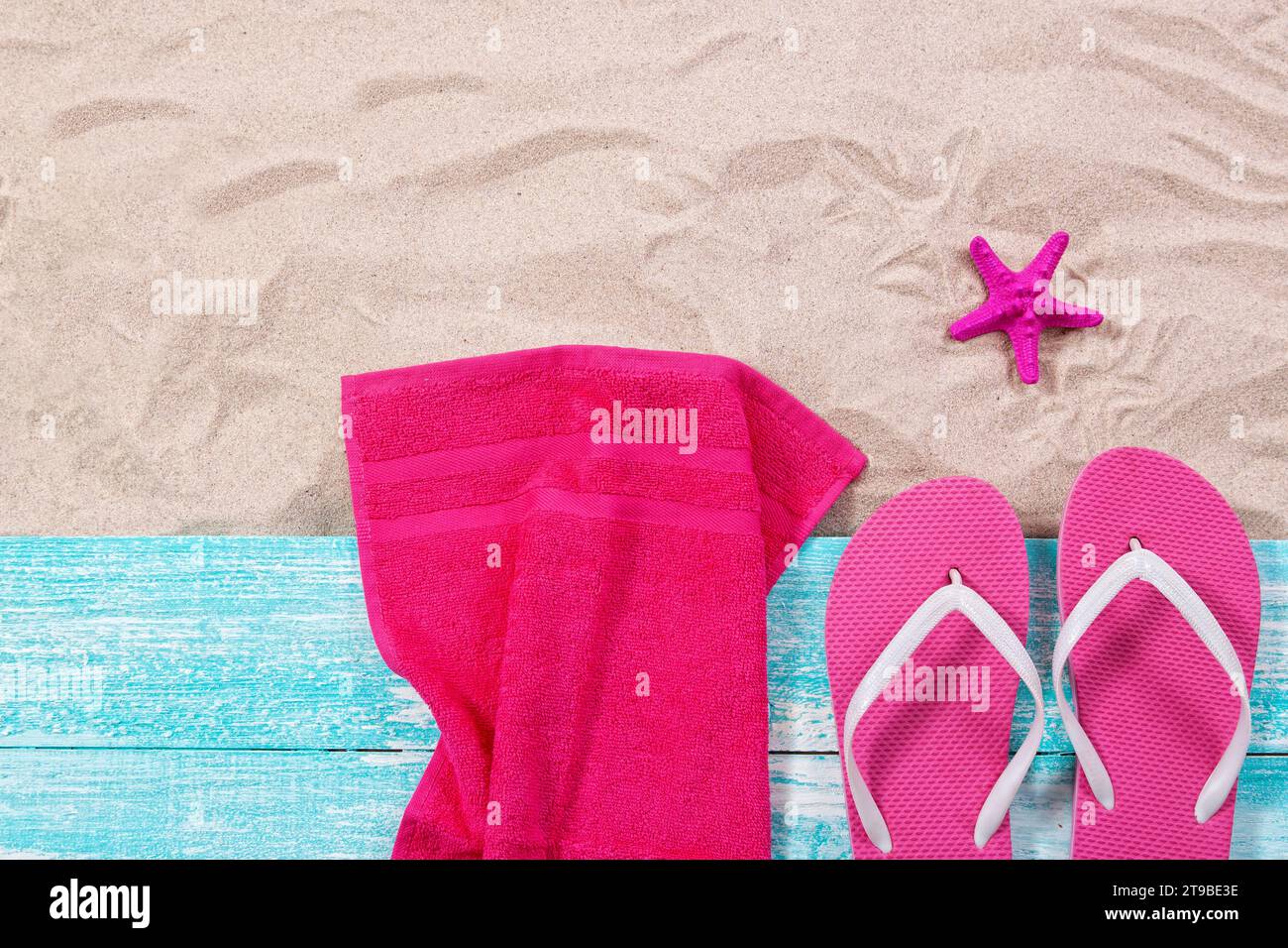Summer towels, flip flops and pink starfish on the sand top view Stock ...