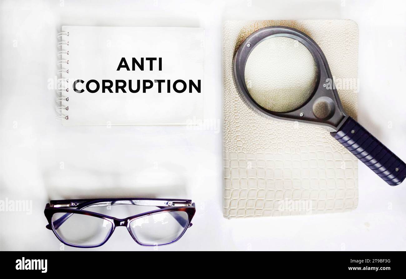Anti-corruption phrase written on a notepad and white background. Stock Photo