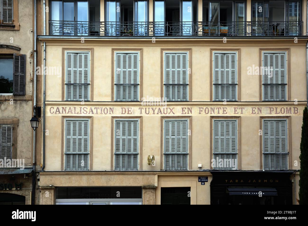 Old Shutters & Window Pattern with Old Painted Company Name or Plumber Advert on Place du Verdun Old Town Aix-en-Provence Provence France Stock Photo