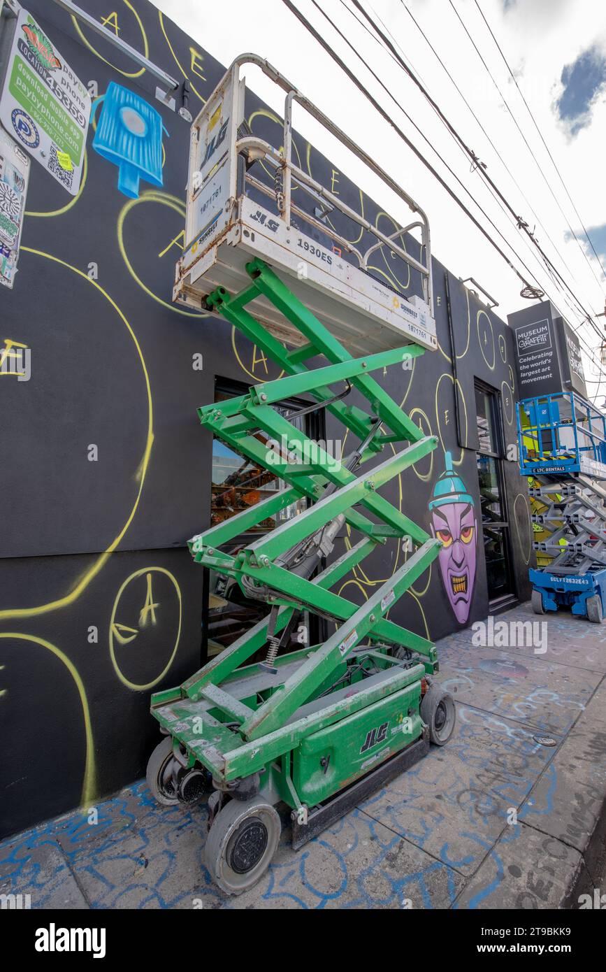 Miami, FL—Nov 20, 2023; Scissor lift in Wynwood Art District. The district, home to over 10 galleries, museums and collections, used to paint street a Stock Photo