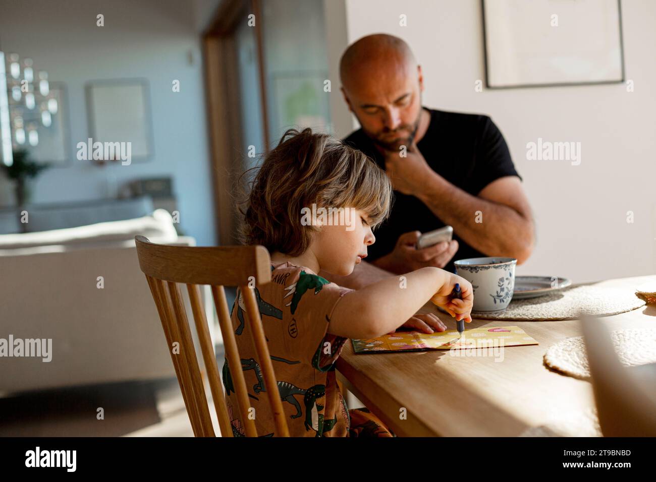 Father and son sitting at table Stock Photo
