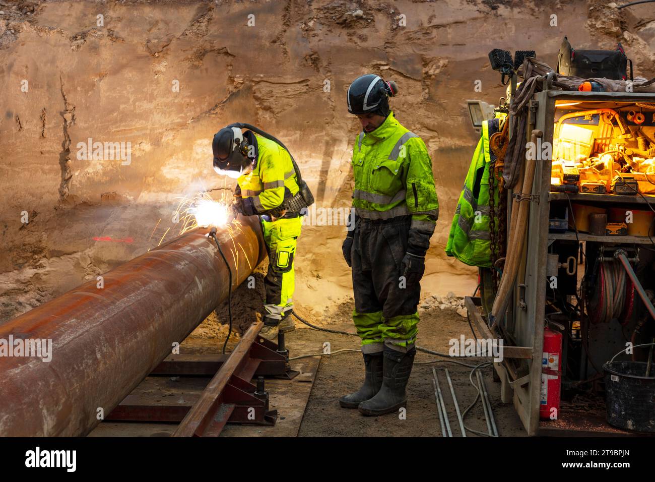View of workers welding pipes at construction site Stock Photo