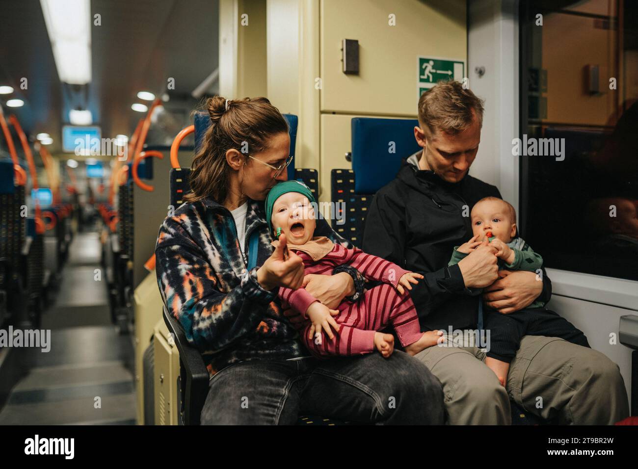 Parents traveling with babies by train Stock Photo