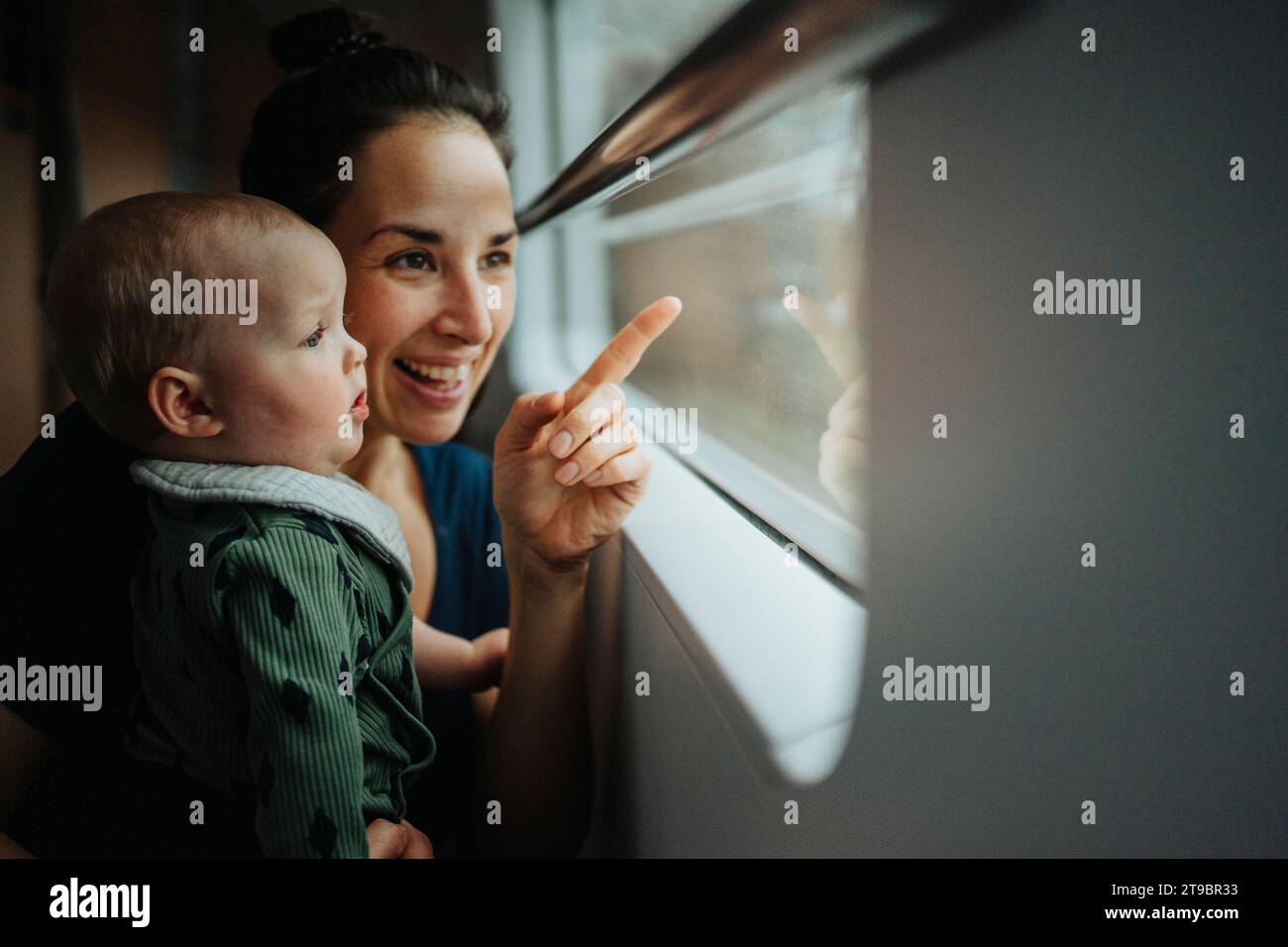 Mother with baby looking through window Stock Photo