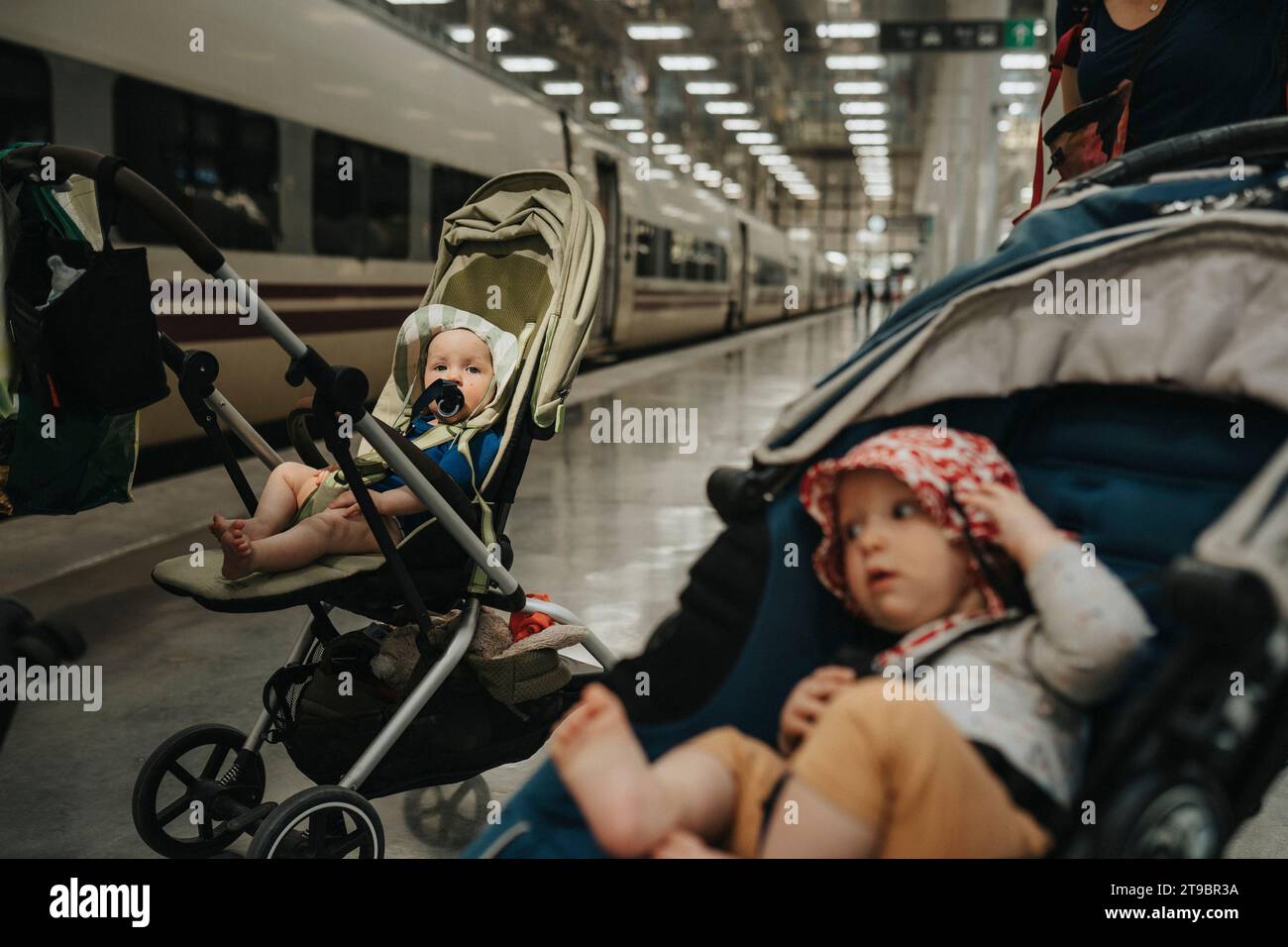 Babies in strollers at train station Stock Photo