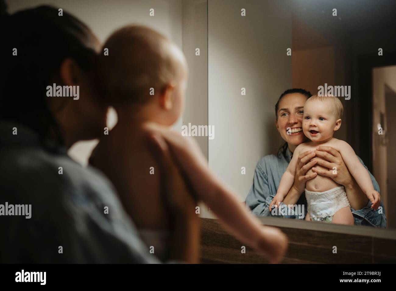 Mother and baby looking in mirror after shower Stock Photo